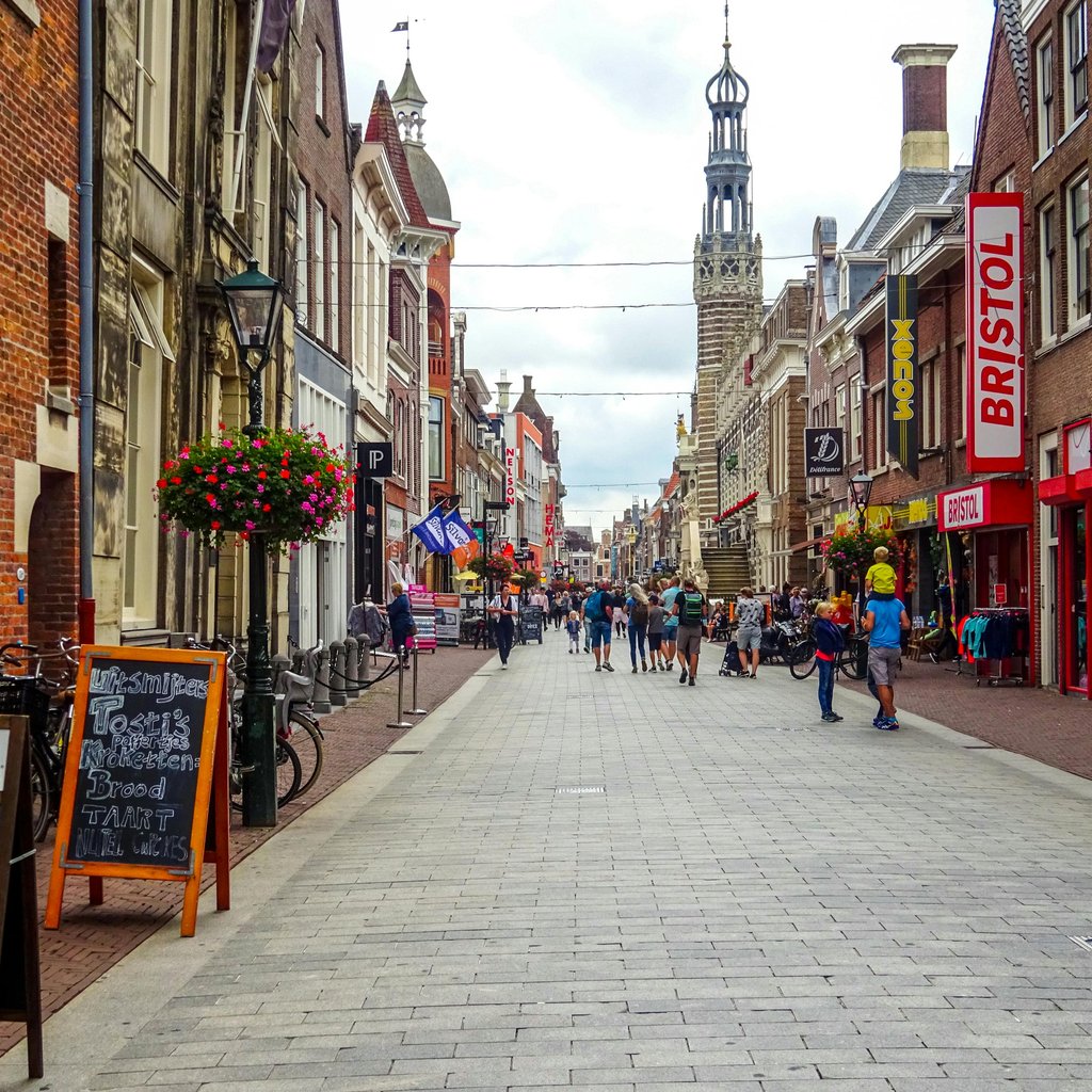 Vibrant street scene in Alkmaar, Netherlands, featuring historic architecture and lively shops.