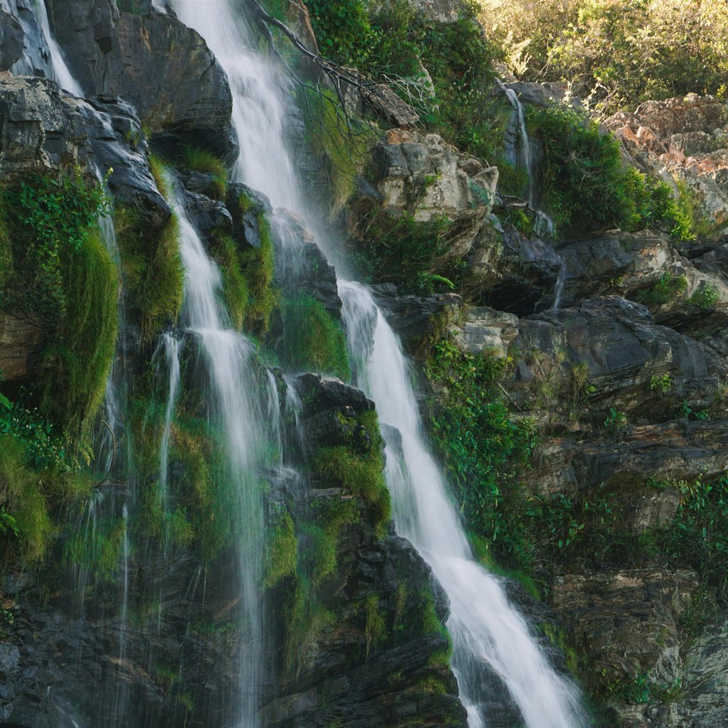 Beautiful vertical shot of a natural waterfall flowing over rocky cliffs in Alto Paraíso de Goiás, Brazil.