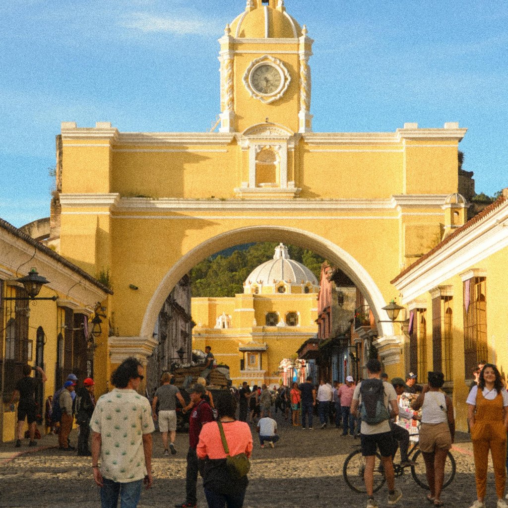 Discover the bustling Santa Catalina Arch in Antigua, capturing vibrant street life on a sunny day.