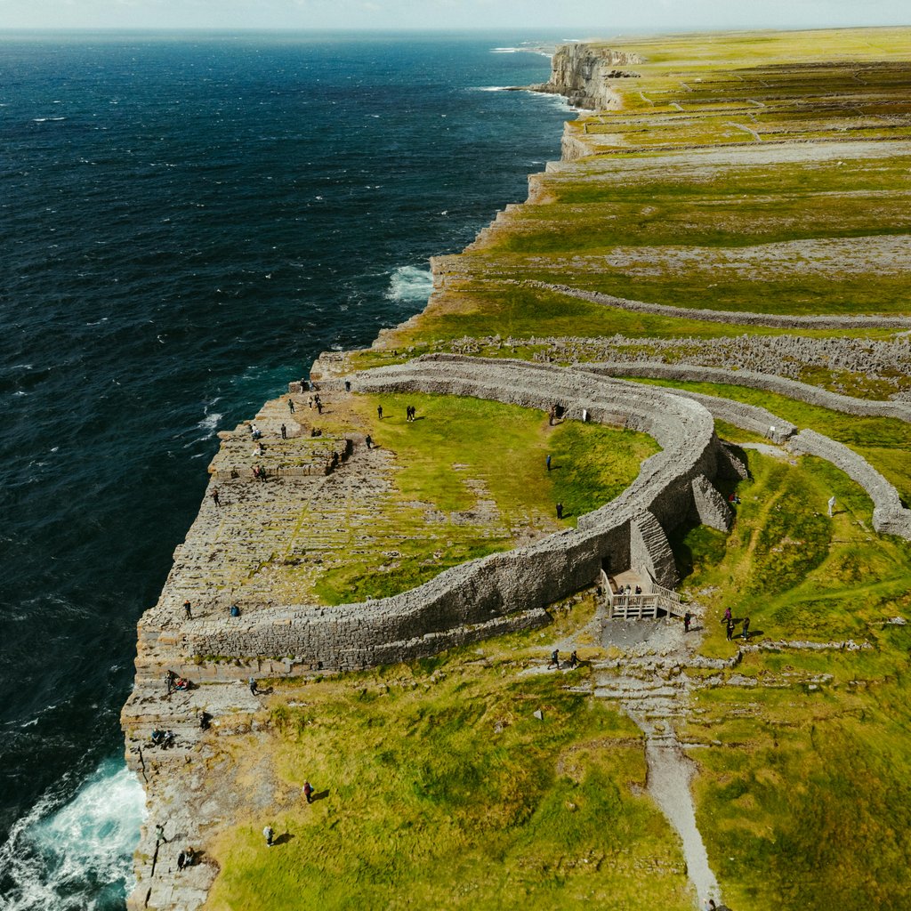 A stunning aerial view of Dun Aonghasa on the Aran Islands, showcasing rugged cliffs and ancient stone fortifications.