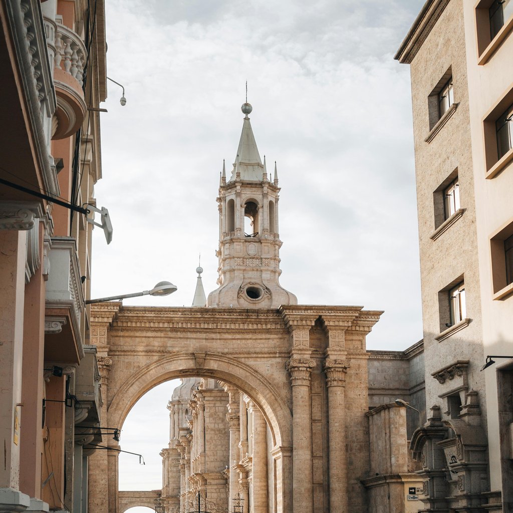 A vibrant street scene with people walking near the Basilica Cathedral in Arequipa, Peru.