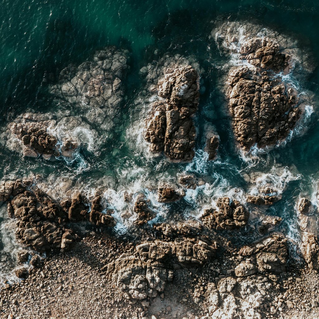 A stunning aerial shot of the rocky coastline and waves in Arica, Chile.
