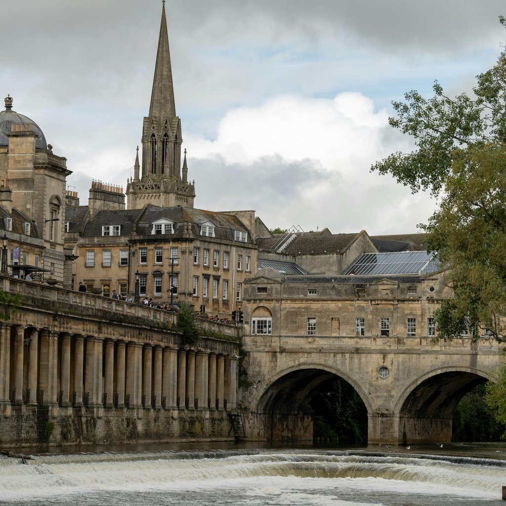 Scenic view of Pulteney Bridge spanning the river in Bath, England with historic architecture.