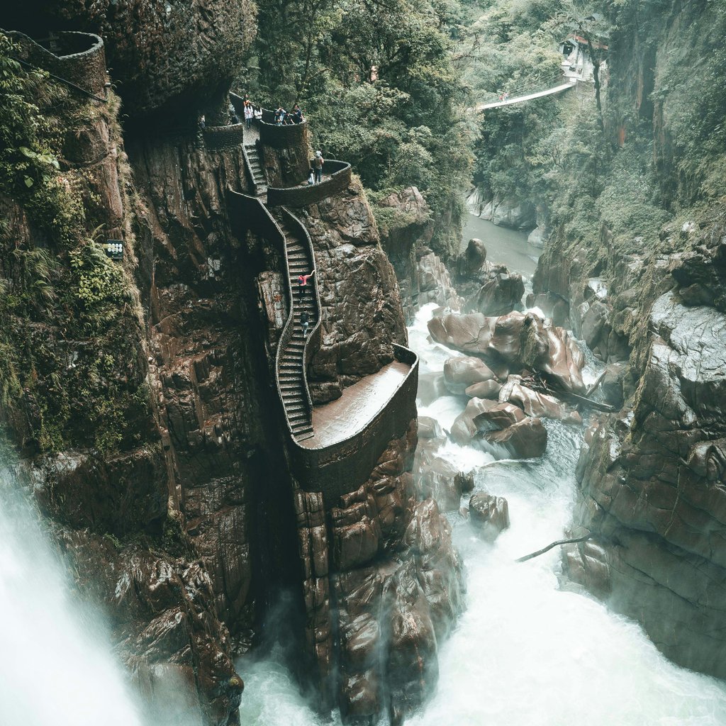 Majestic waterfall with scenic rock stairs amidst lush Ecuadorian landscape