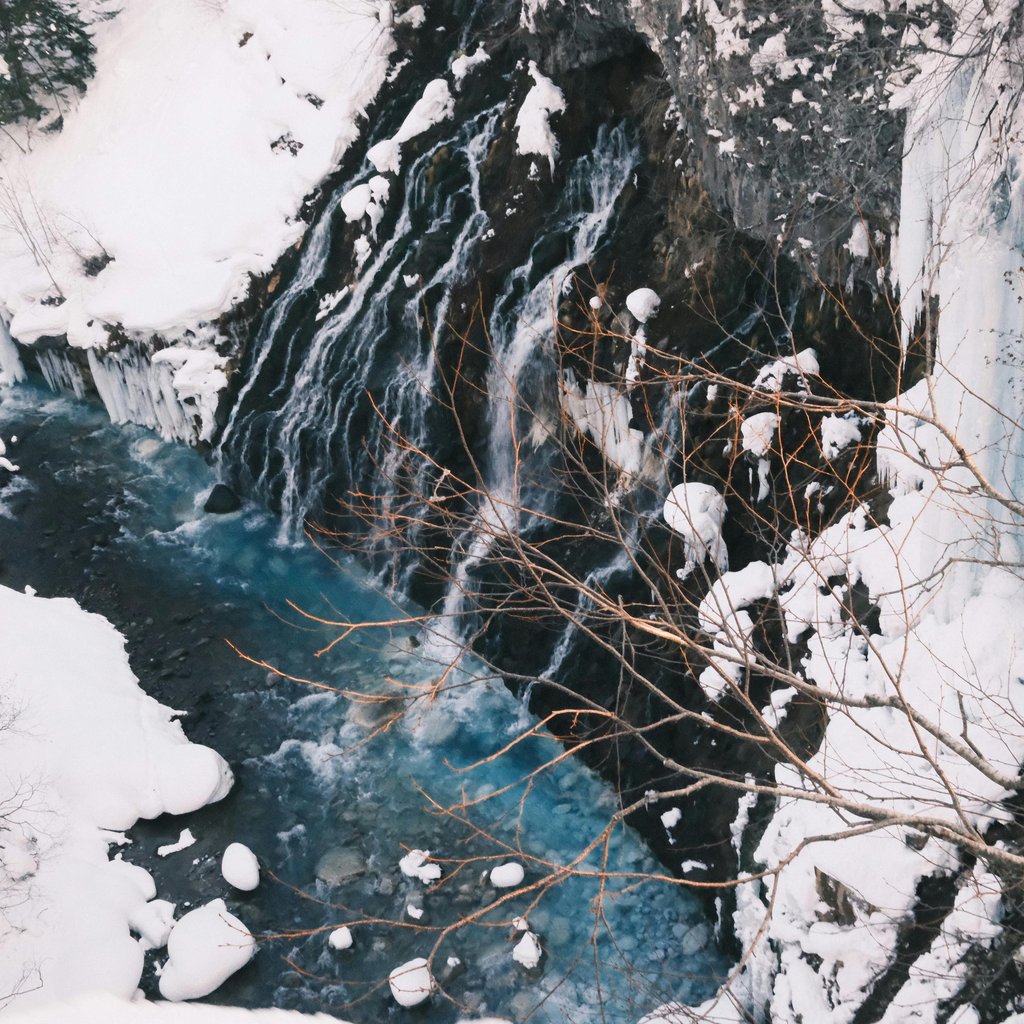Stunning winter view of a frozen waterfall and stream in Biei, Hokkaido.