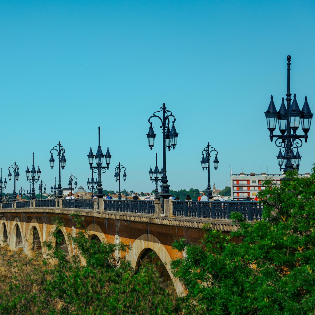 Elegant view of Pont de Pierre bridge in Bordeaux, France on a sunny day.