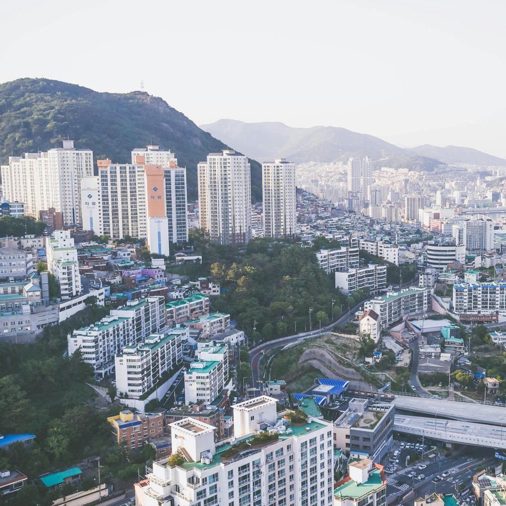 Stunning aerial view of Busan's skyline, featuring high-rise buildings and harbor.