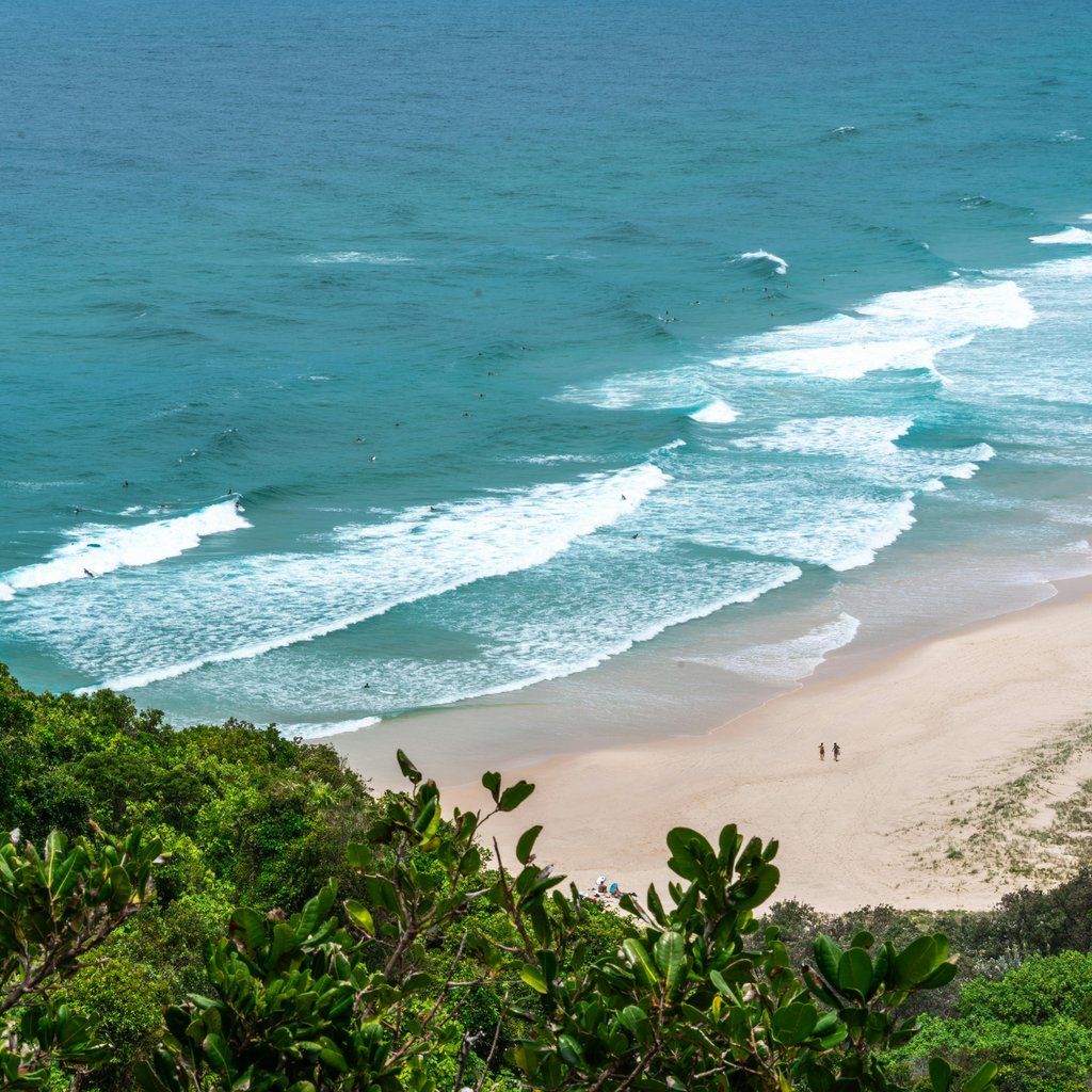 Explore the beautiful sandy beaches and vibrant greenery of Byron Bay from above with this stunning coastal shot.