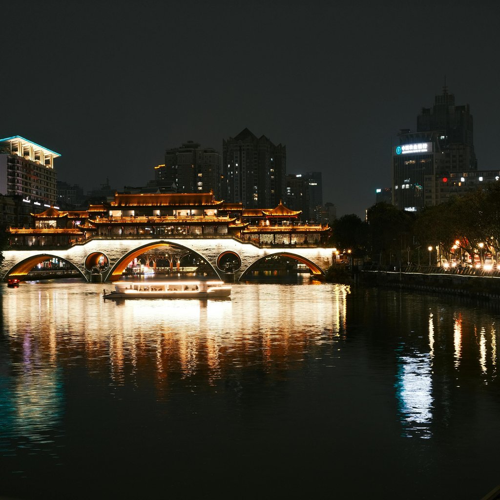Stunning night scene of the illuminated Anshun Bridge and its reflection in Chengdu, China.