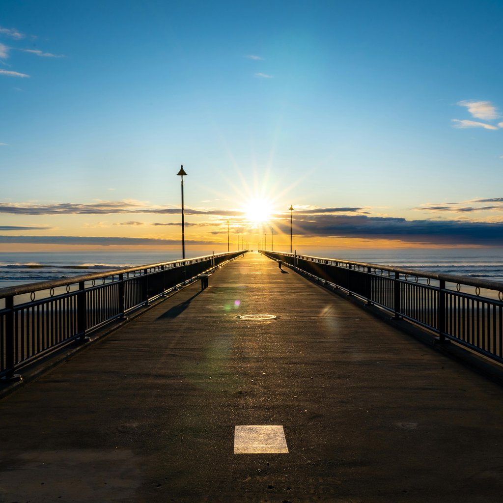 Beautiful sunrise view from the pier in Christchurch, New Zealand with ocean horizon.