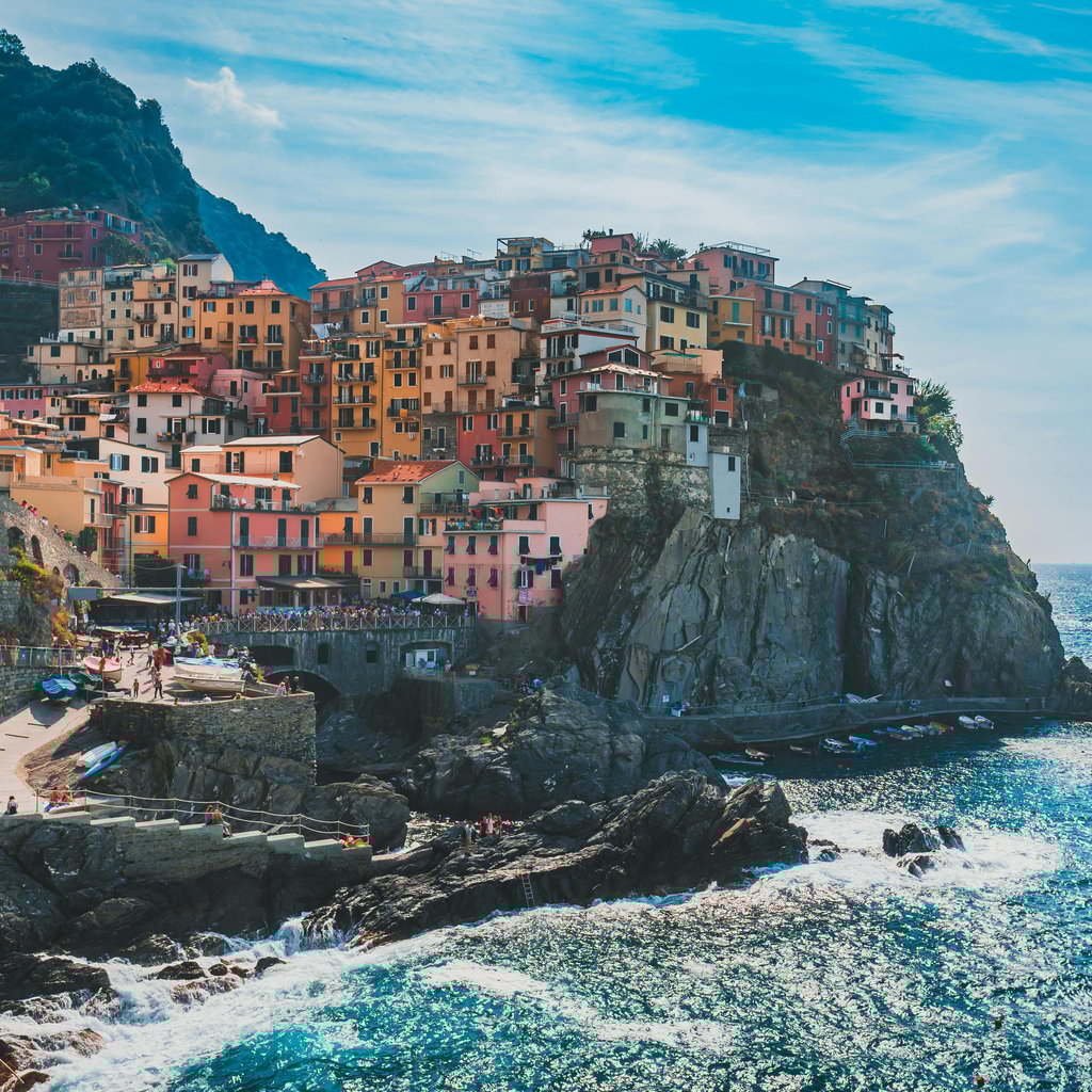 Vibrant houses on a cliff overlooking the ocean in Cinque Terre, Italy. Stunning coastal scenery.