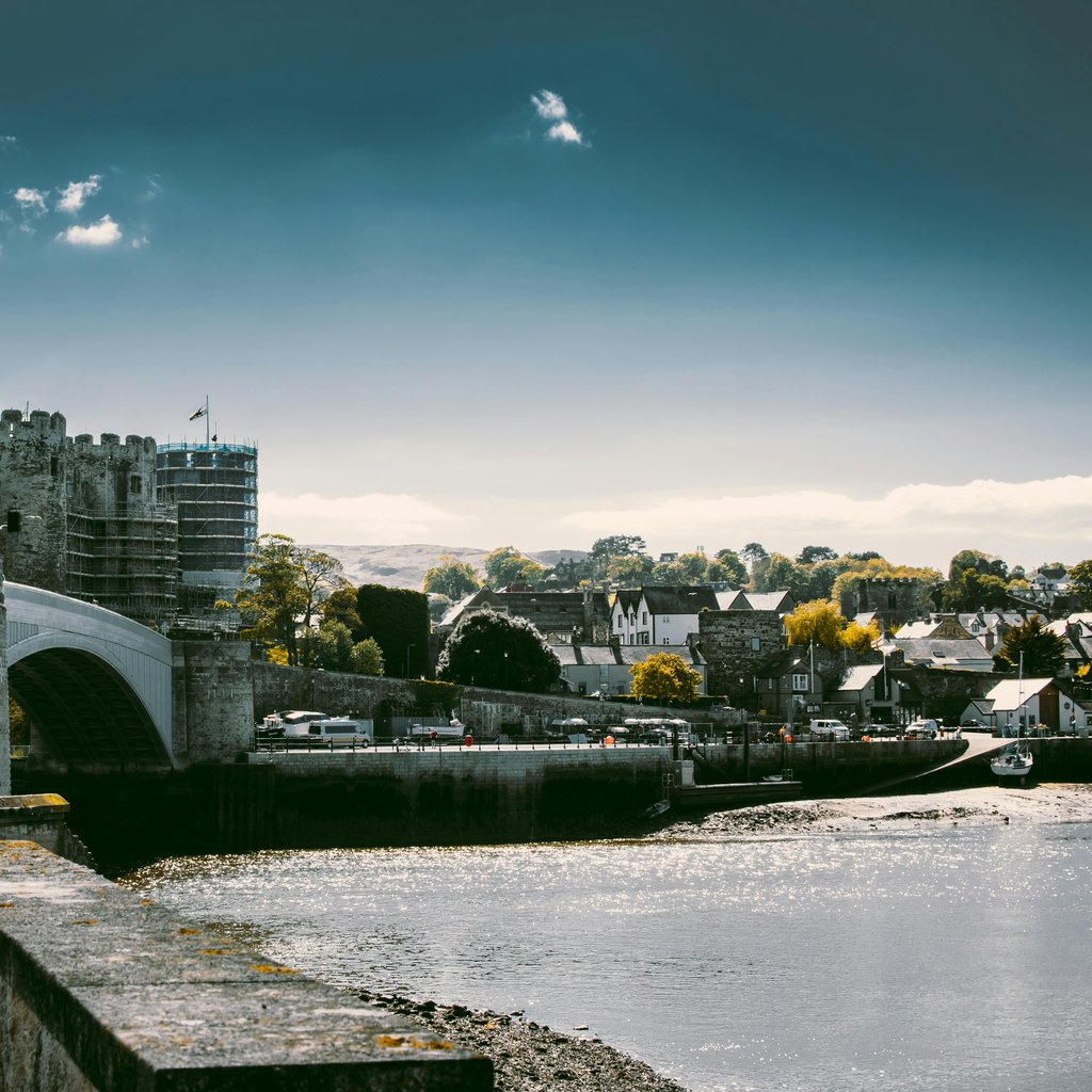 A captivating shot of the historic Conwy Castle and bridge under a vibrant sky in Wales.