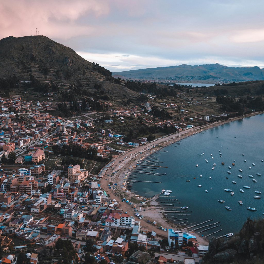 Scenic aerial view of Copacabana, Bolivia with boats and town nestled by the serene Lake Titicaca.
