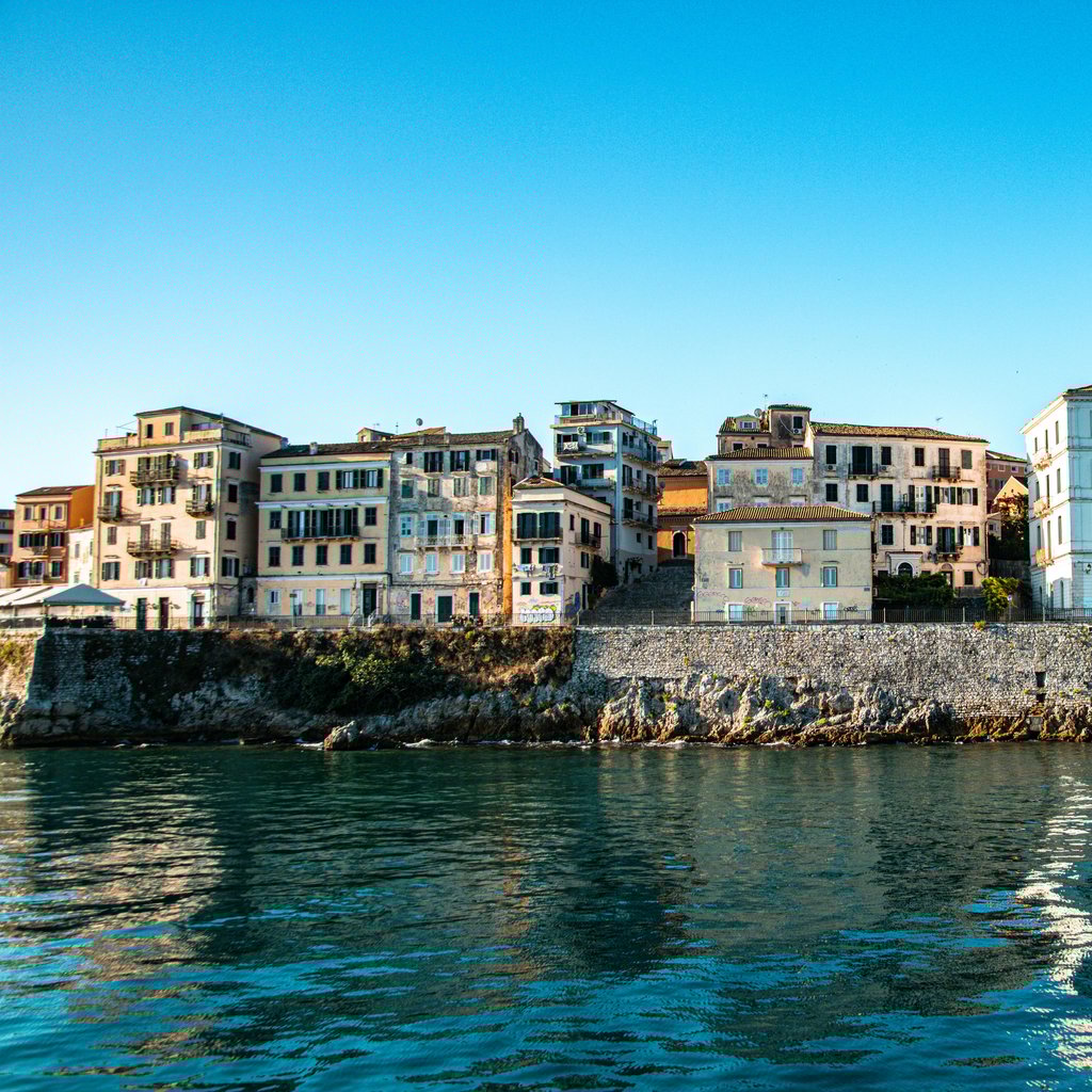 Stunning view of coastal buildings in Corfu, Greece under a clear blue sky.