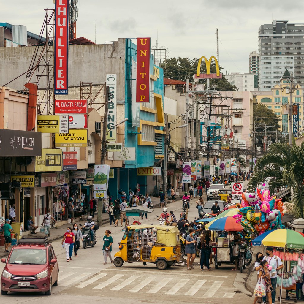 Vibrant urban street scene in Davao City with diverse shops and pedestrians.