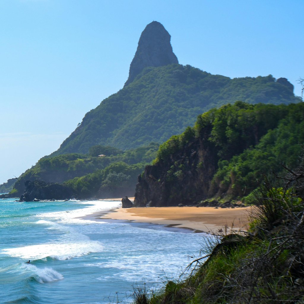 Explore the pristine beach and iconic peak in Fernando de Noronha, Brazil, a true tropical paradise.