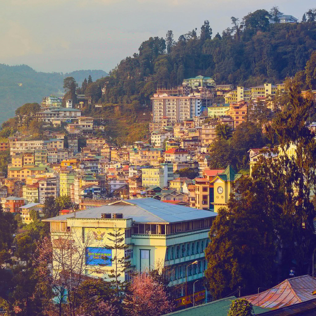 Stunning view of Gangtok, Sikkim at sunset showcasing vibrant urban landscape and scenic hills.