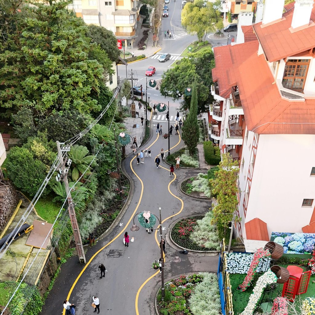 Aerial view of a curved road surrounded by lush greenery in Gramado, Brazil.