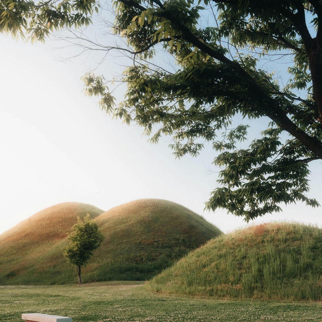 Serene landscape of ancient burial mounds in Gyeongju, South Korea.