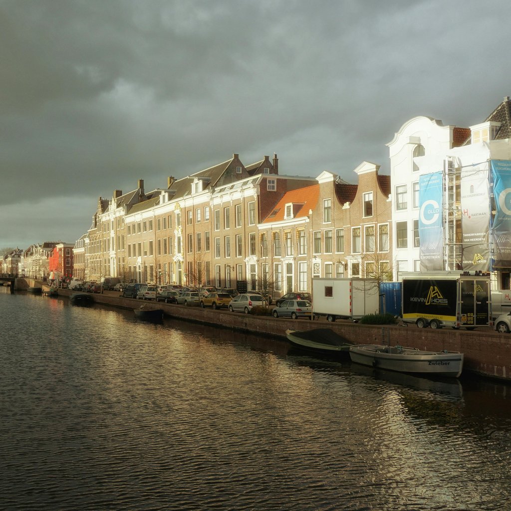 Beautiful view of a historic canal in Haarlem under dramatic clouds.