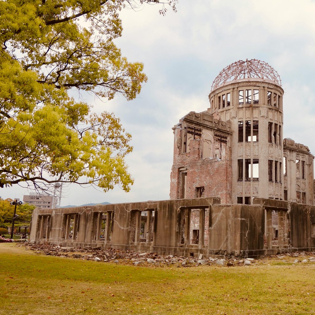 The iconic Hiroshima Genbaku Dome, a UNESCO World Heritage Site, set amidst spring foliage.