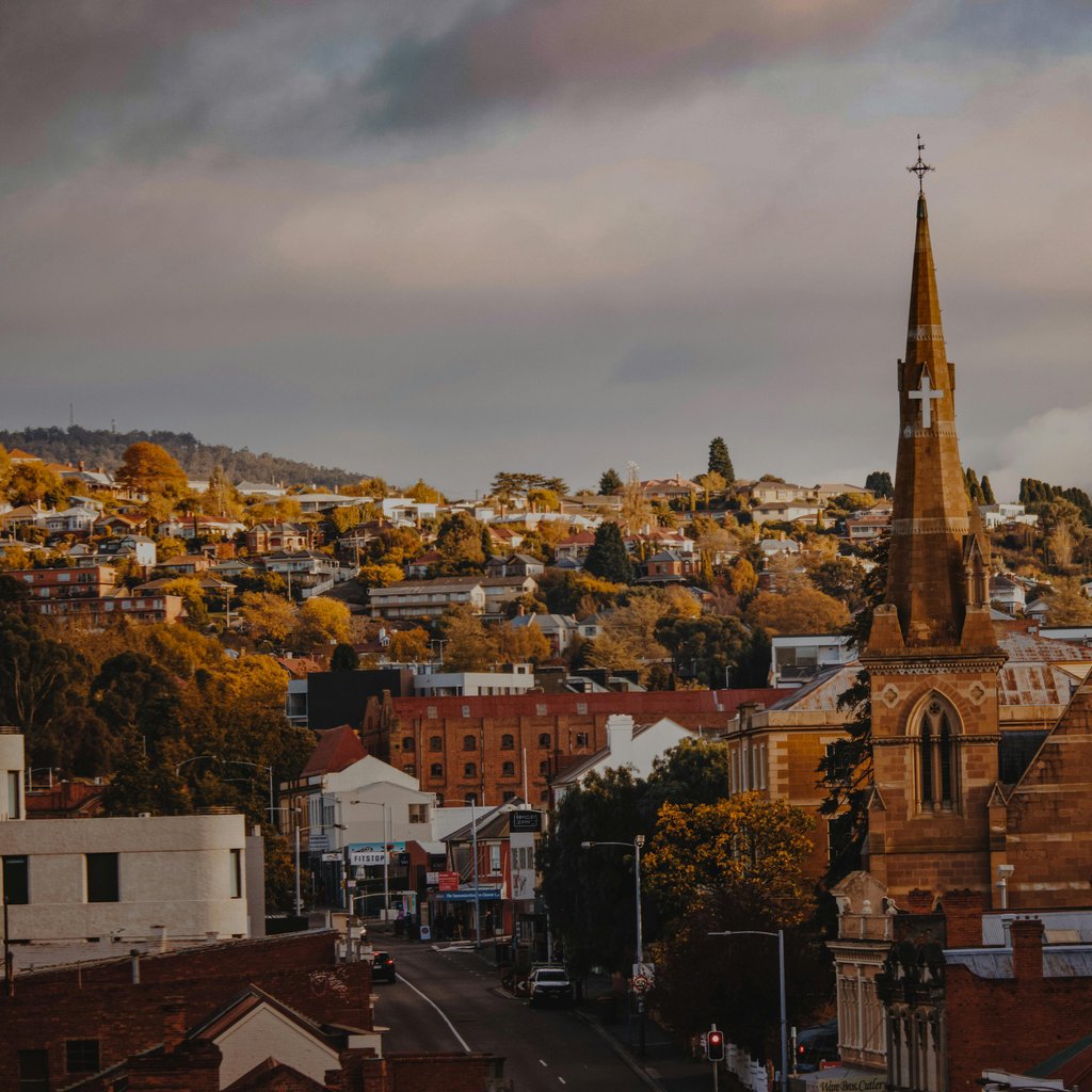 A picturesque view of a historic church and townscape in Hobart, Tasmania with a moody backdrop.