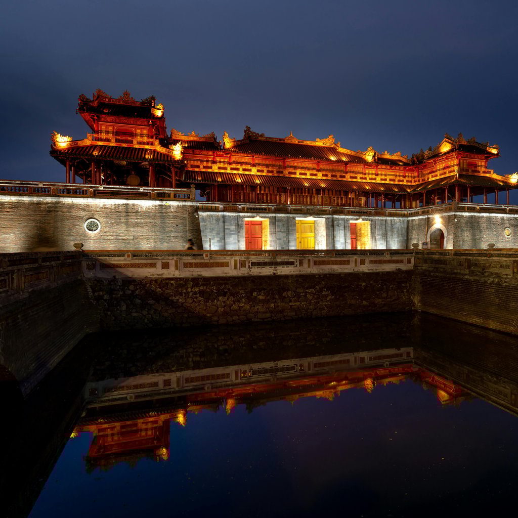 Scenic night view of the Imperial City in Hue with reflections on the water.