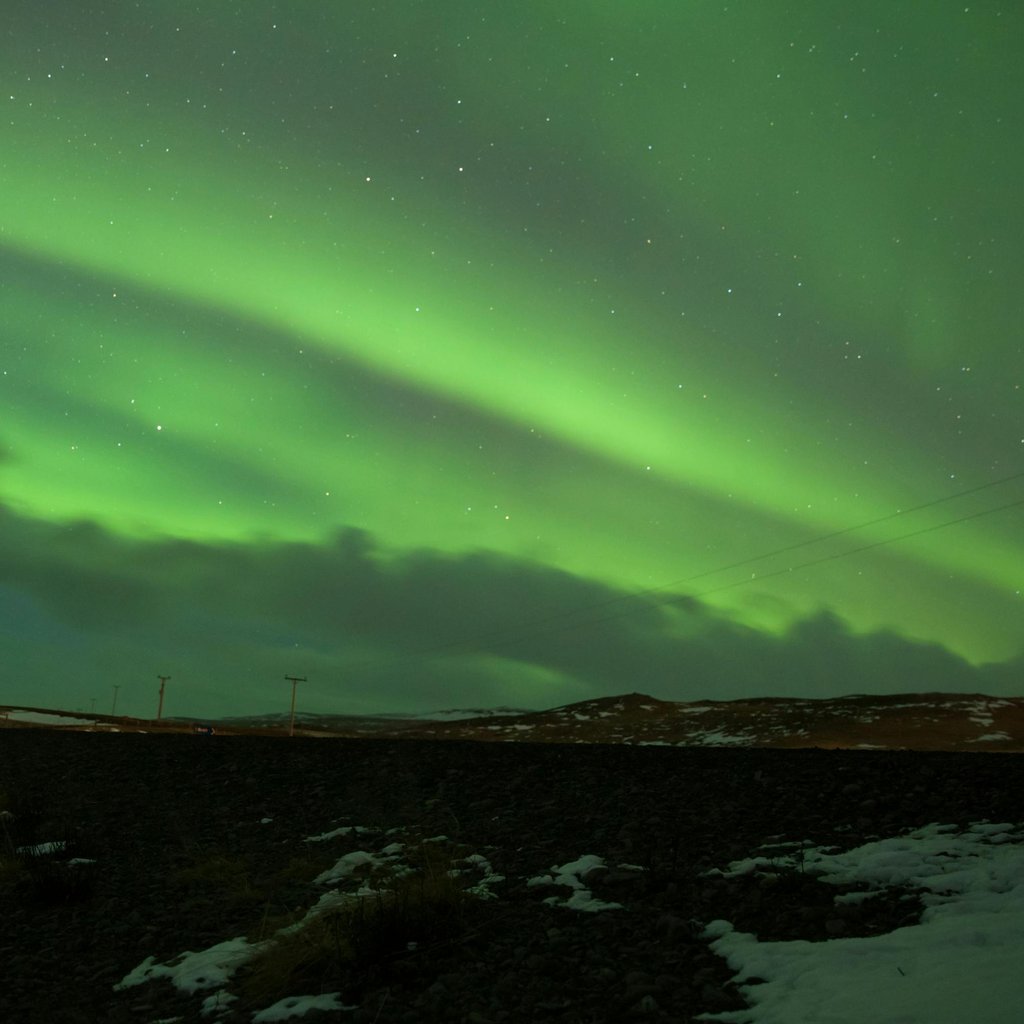 Captivating view of the Northern Lights illuminating the night sky in Hvammstangi, Iceland.