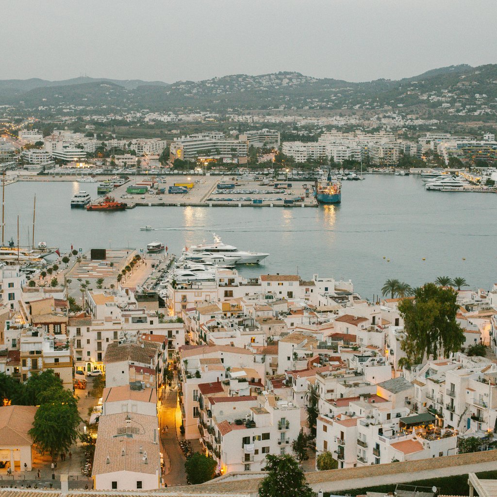 Aerial view of the vibrant Ibiza port with yachts and panoramic cityscape.