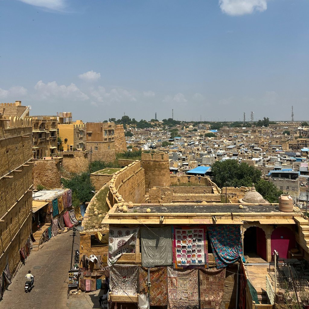 Aerial view of Jaisalmer's golden architecture under a vibrant sky in Rajasthan, India.