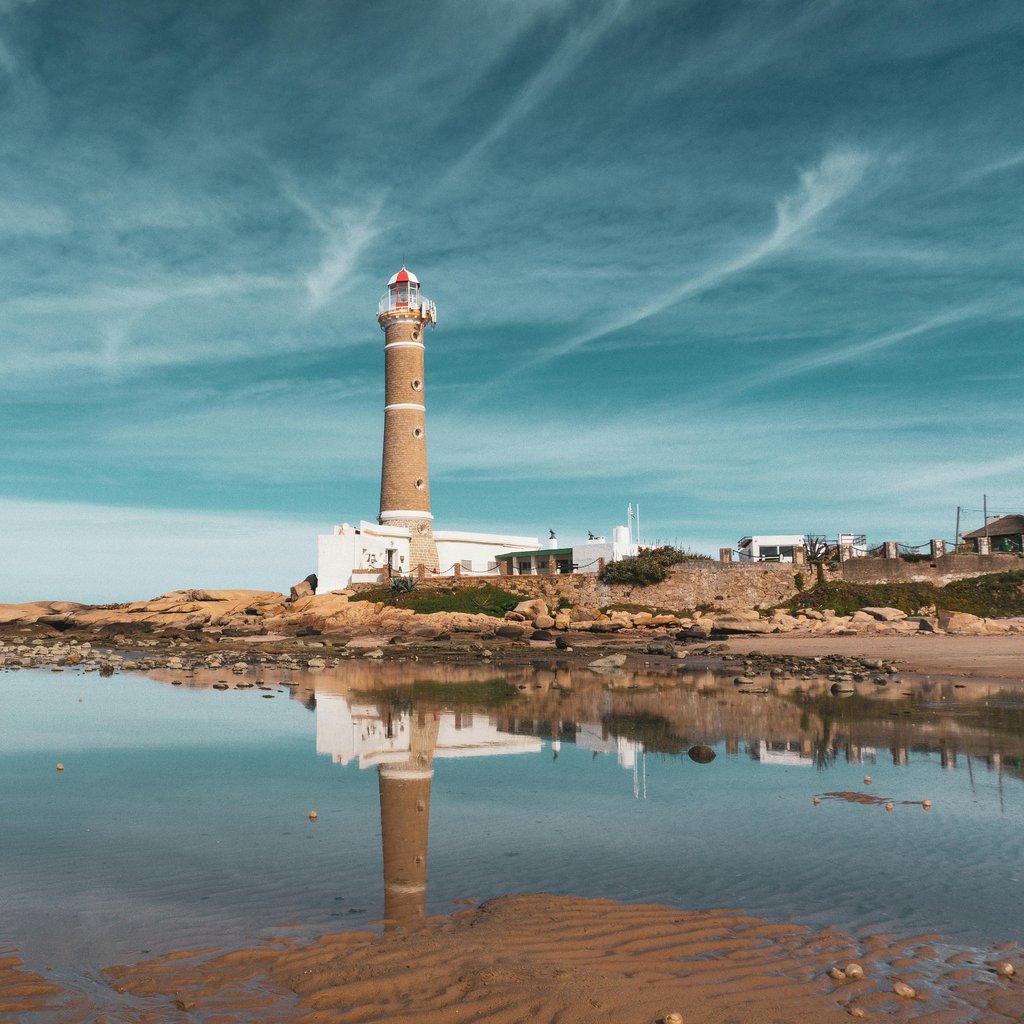 Beautiful seaside view of Faro de José Ignacio lighthouse reflecting in the calm water.