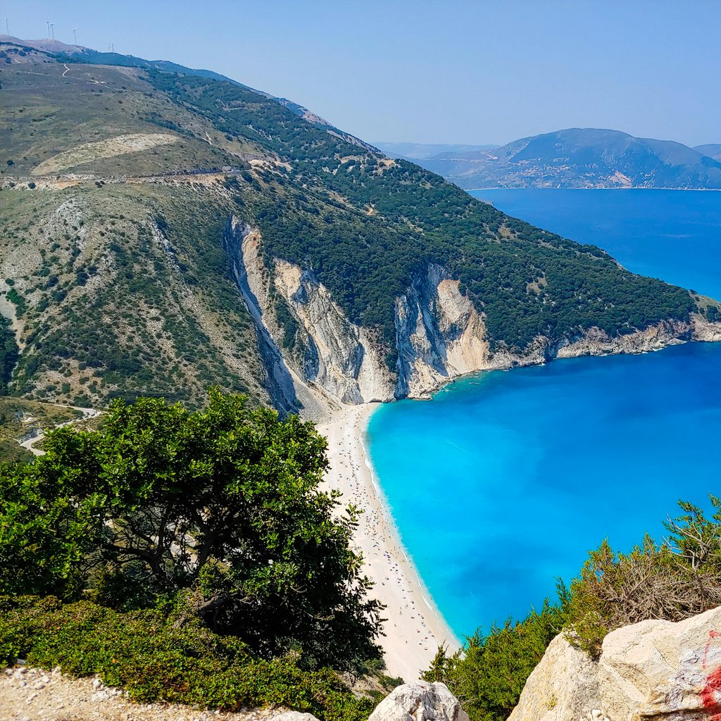 Stunning aerial view of Myrtos Beach with turquoise waters and rugged cliffs on Kefalonia Island, Greece.
