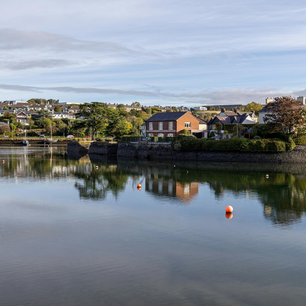 Charming houses reflect in the calm waters of Kinsale, County Cork, Ireland.