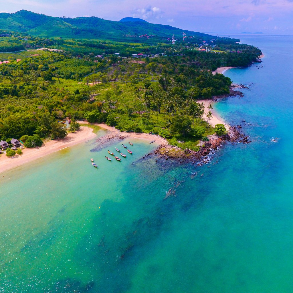 Stunning aerial view of a tropical beach and lush green landscape in Koh Lanta, Thailand.