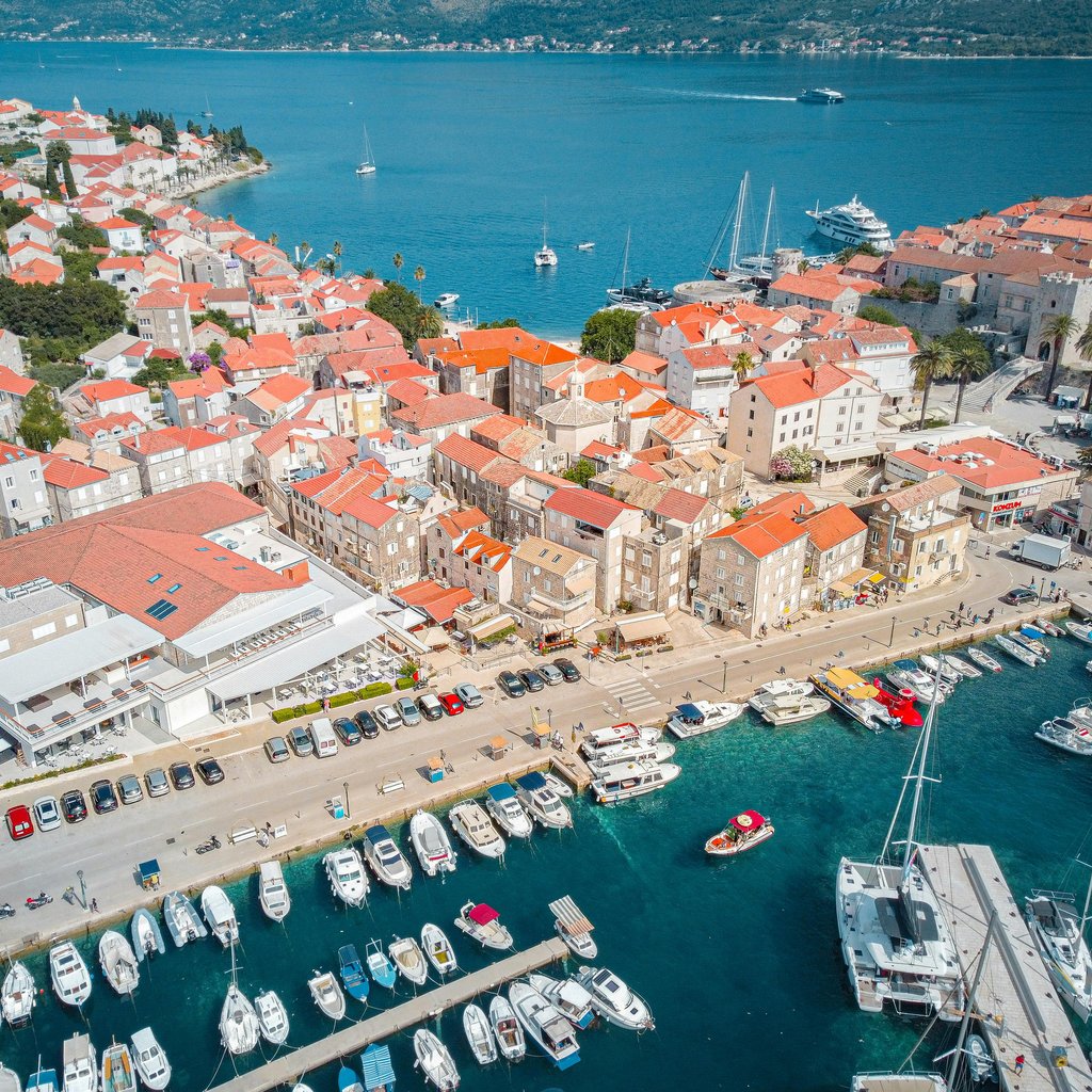 A stunning aerial view of Korcula's old town and marina with vibrant blue sea.