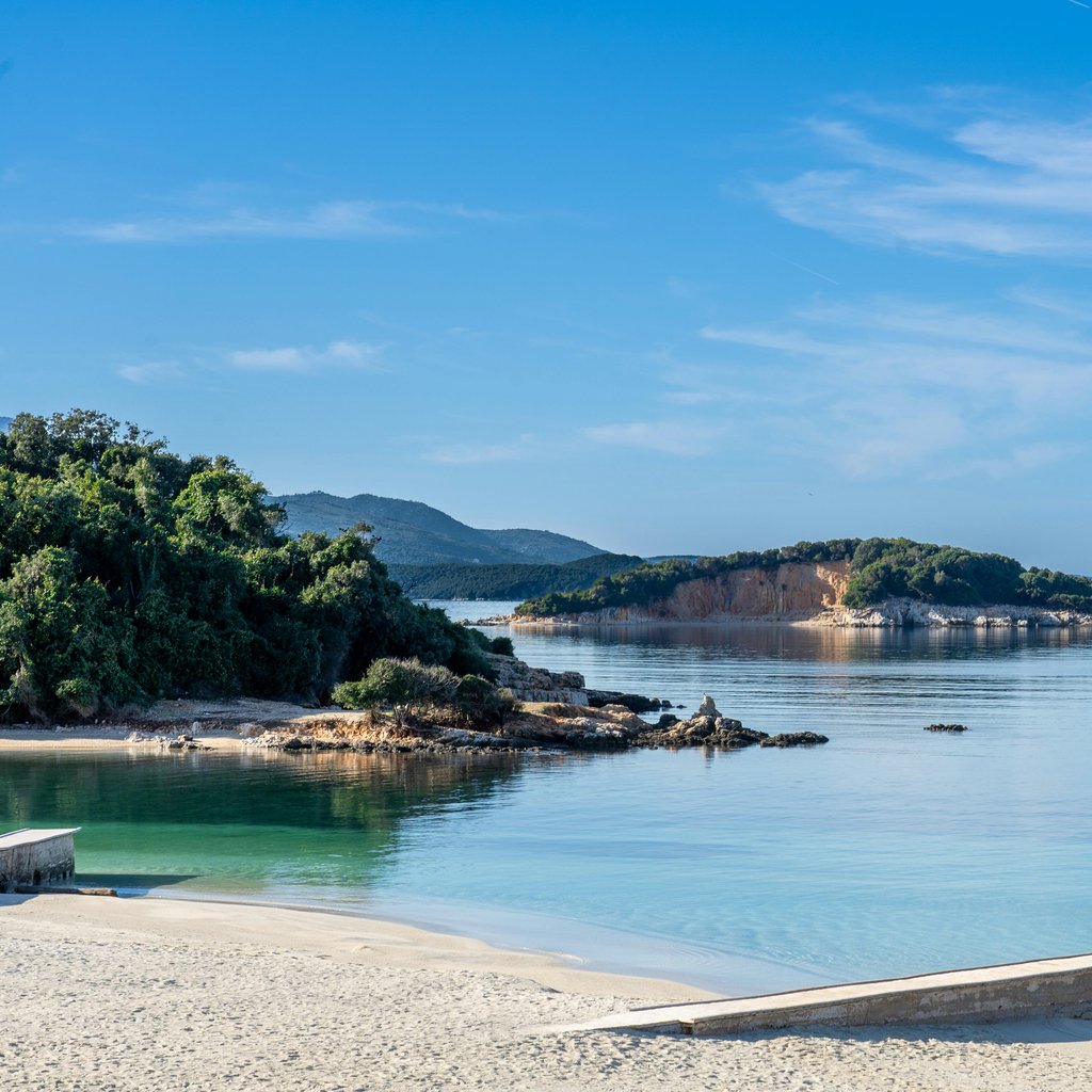 Beautiful beach with clear waters and lush greenery in Ksamil, Albania.