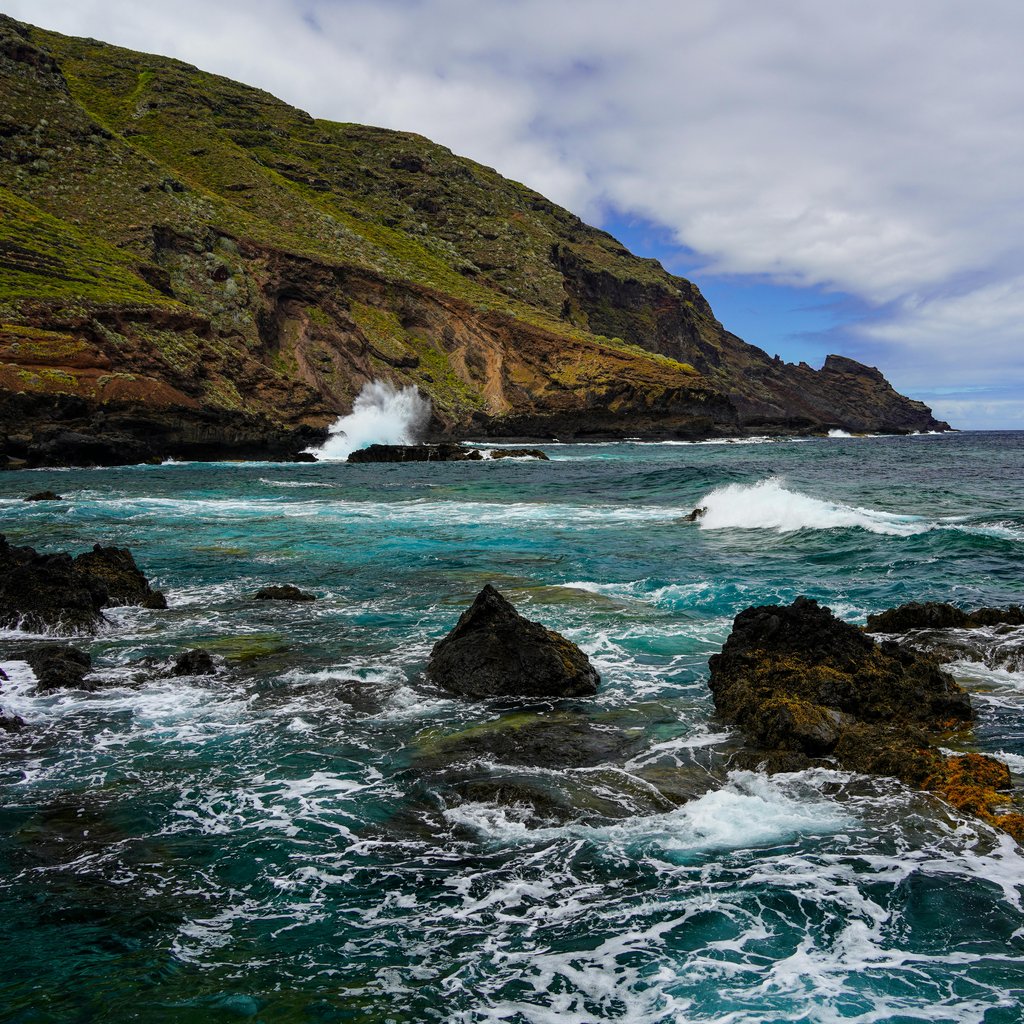 Stunning coastal view with waves crashing on rocky shores in La Palma, Spain.