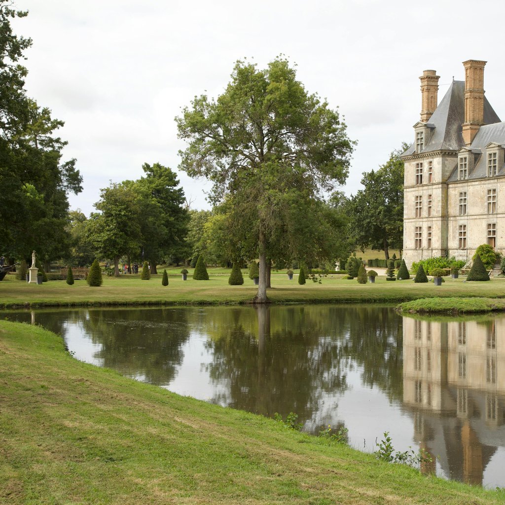 Elegant French chateau with garden and pond reflection in La Rochelle.