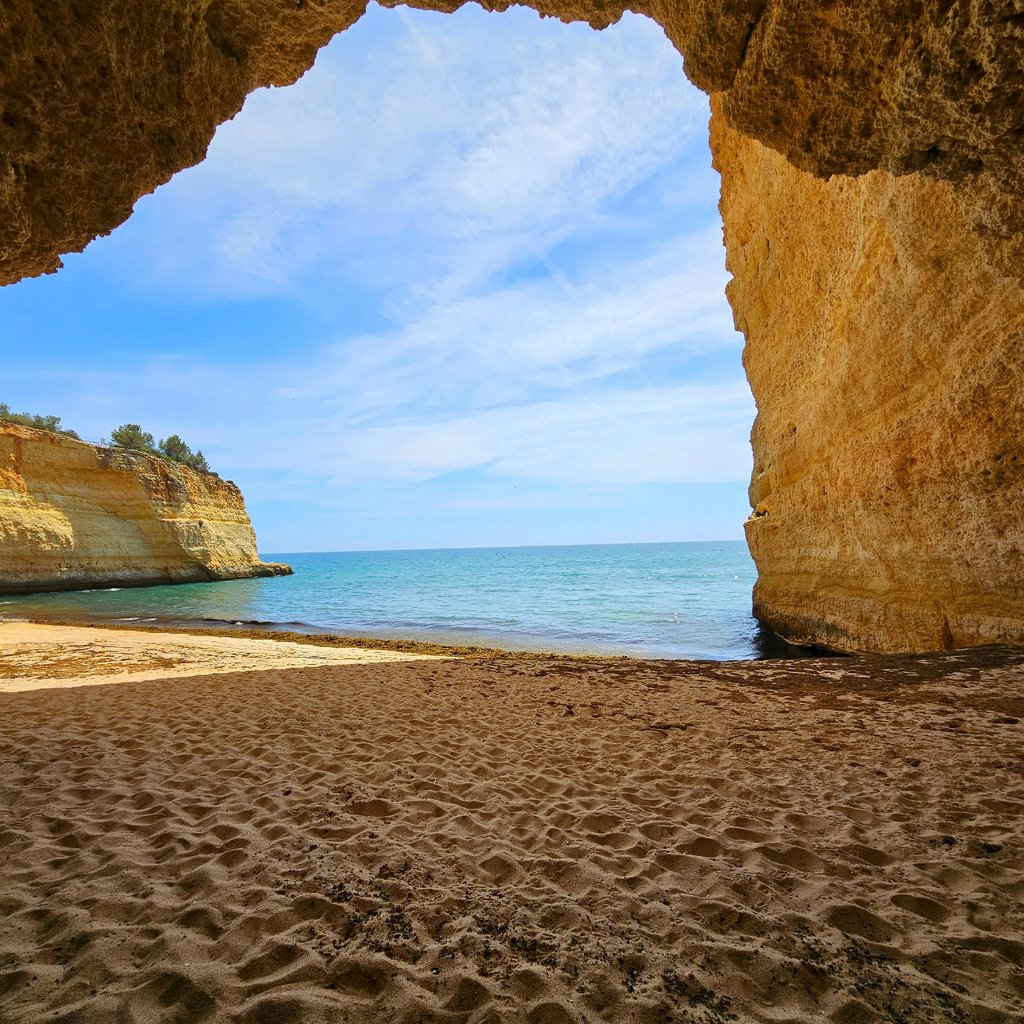 Coastal cave in Algarve, Portugal revealing a stunning view of the sea and cliffs.