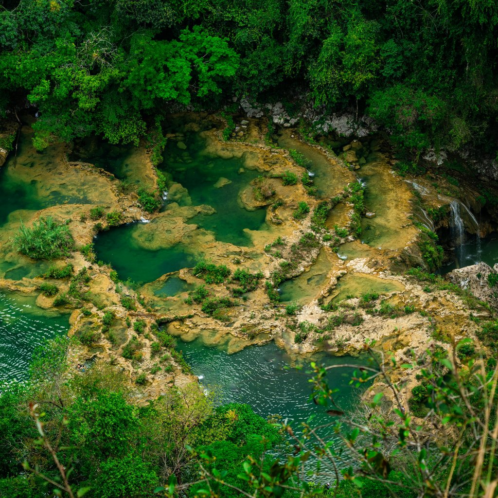 Aerial view of the natural turquoise pools and lush forest at Semuc Champey, Guatemala.