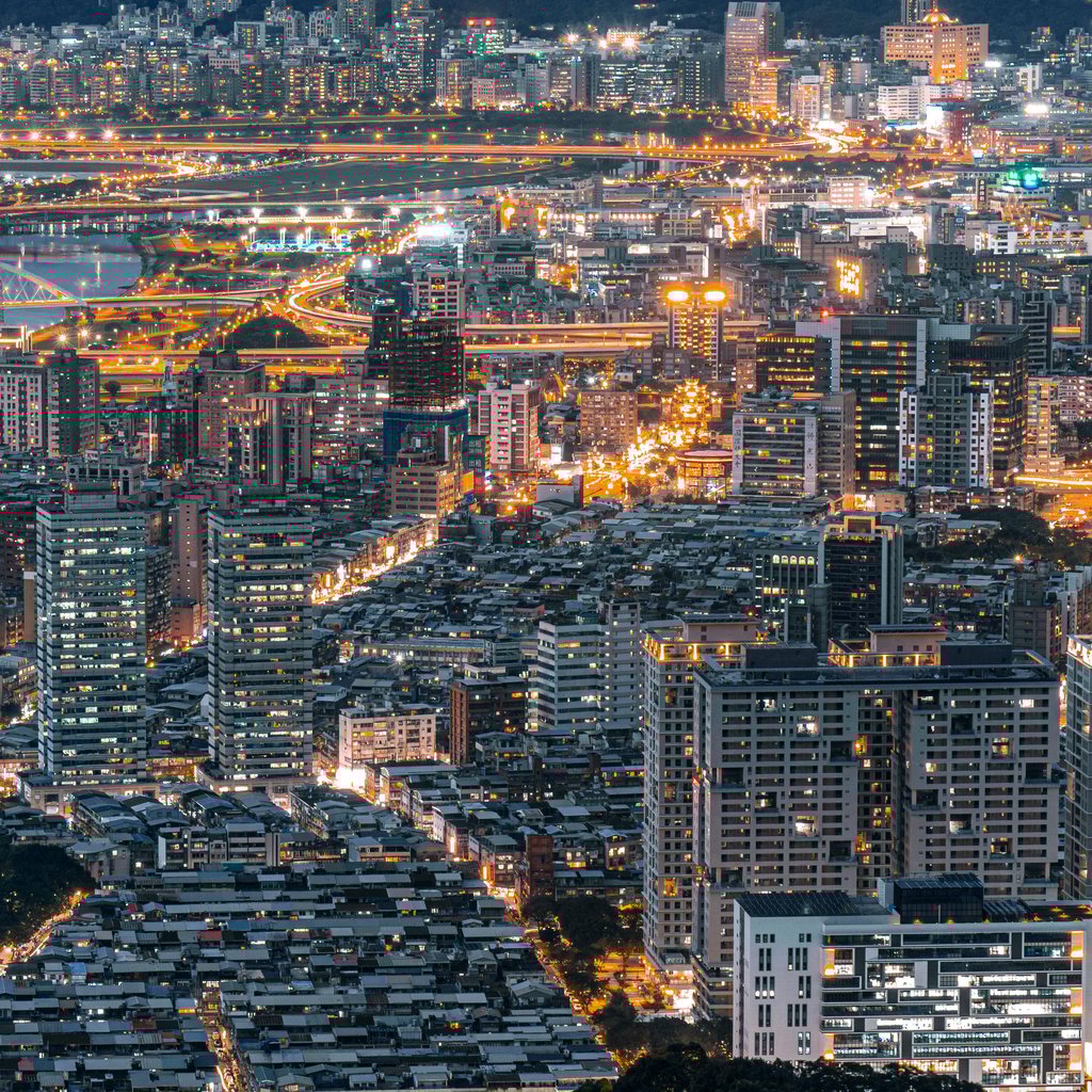 Stunning aerial view of a bustling city illuminated at night, showcasing vibrant urban life.