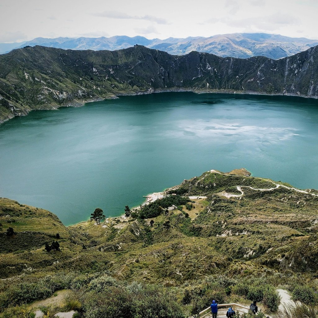 Breathtaking aerial view of Quilotoa crater lake surrounded by the majestic Andes mountains in Ecuador.