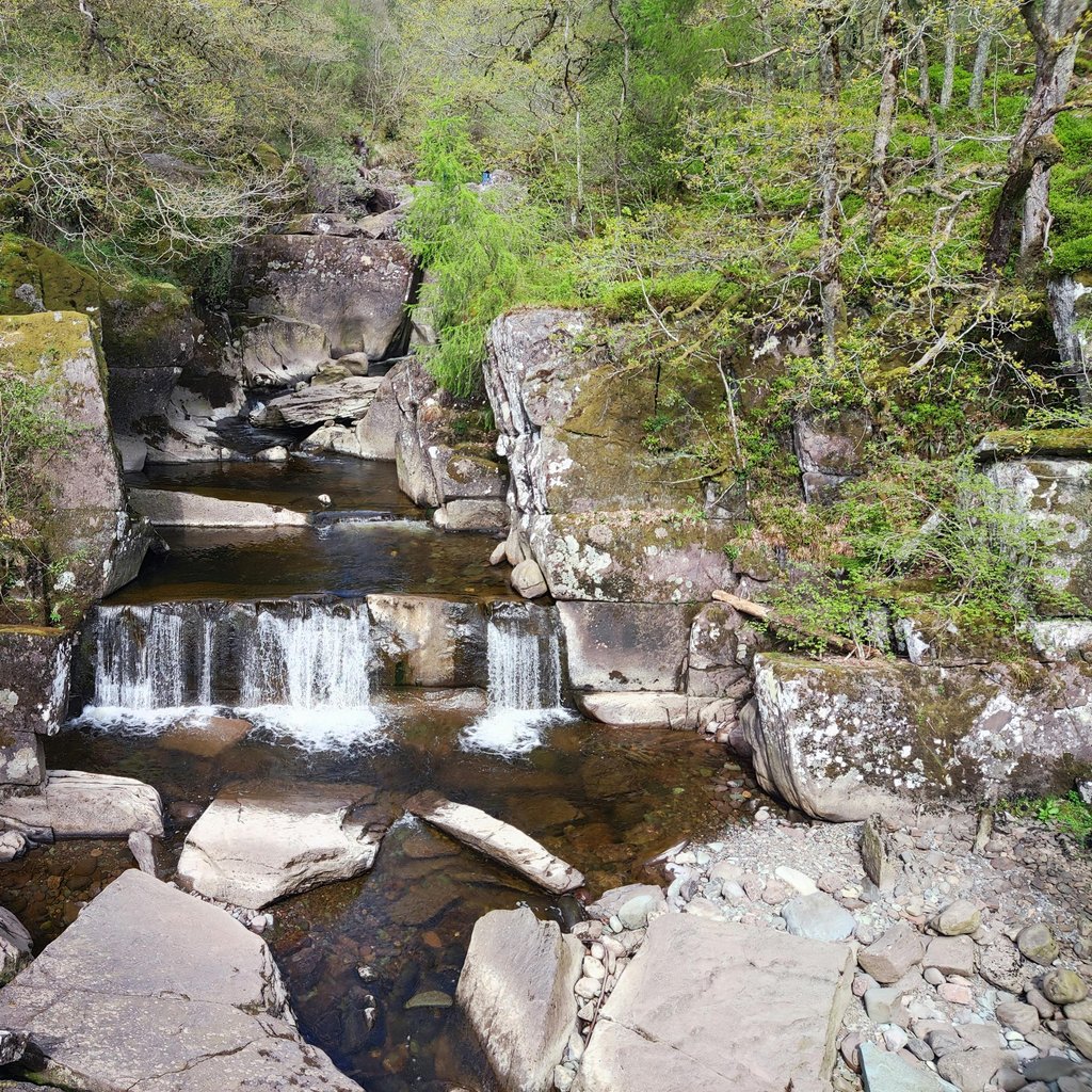 A picturesque view of Bracklinn Falls surrounded by lush greenery in Callander, Scotland.