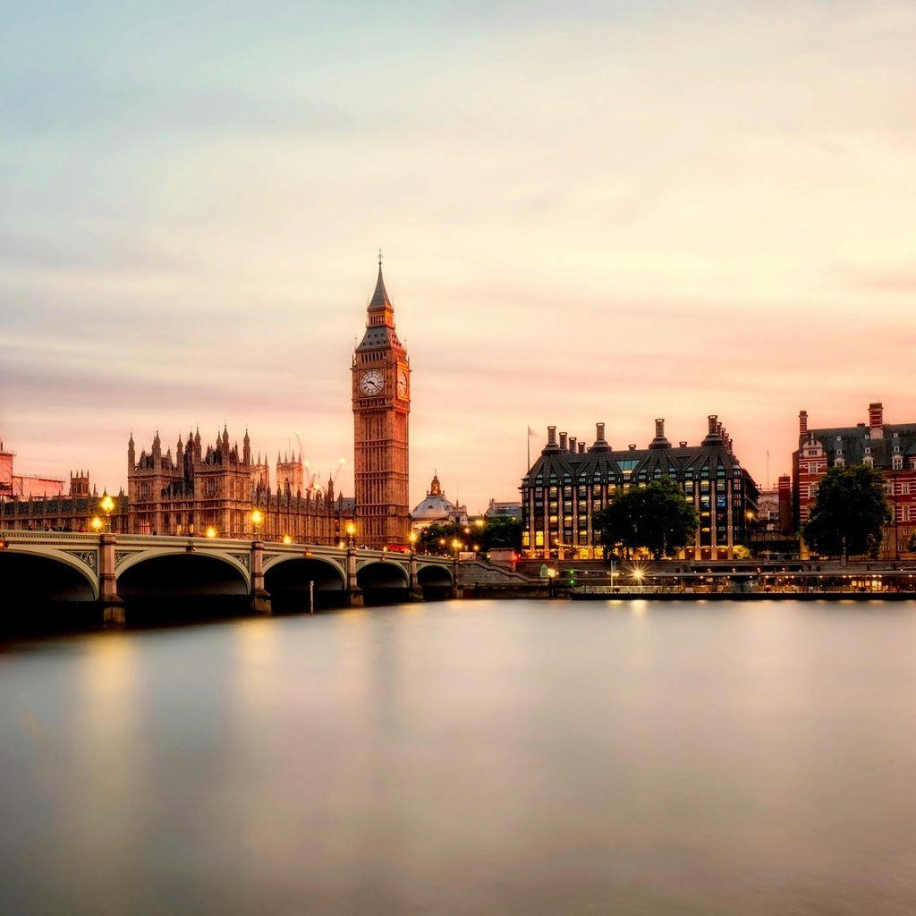 Scenic view of Big Ben and Westminster Bridge over the Thames River at sunset in London, UK.