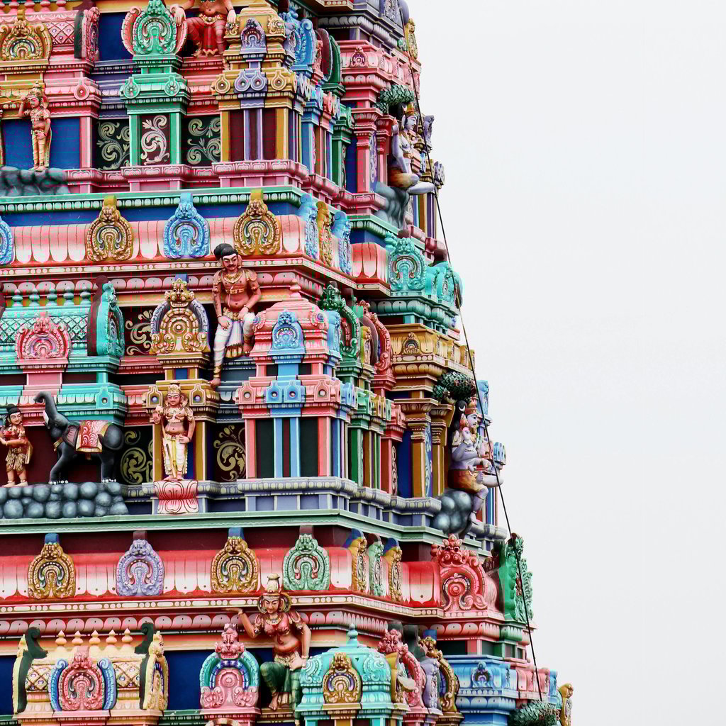 Vibrant facade of Meenakshi Temple's gopura in Madurai, India, showcasing intricate Hindu art.