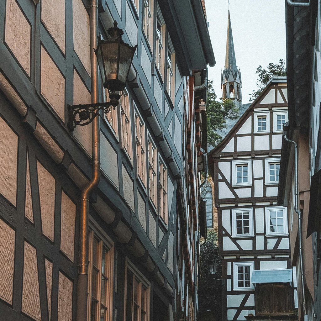 A picturesque alley in Marburg, Germany, featuring traditional half-timbered architecture at dusk.