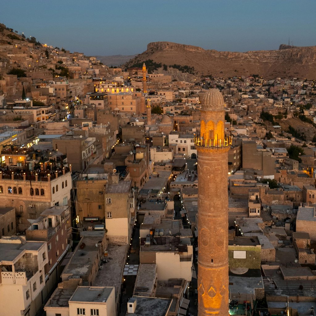 Breathtaking aerial view of Mardin's historic minaret and cityscape at twilight, capturing the essence of Turkish architecture.