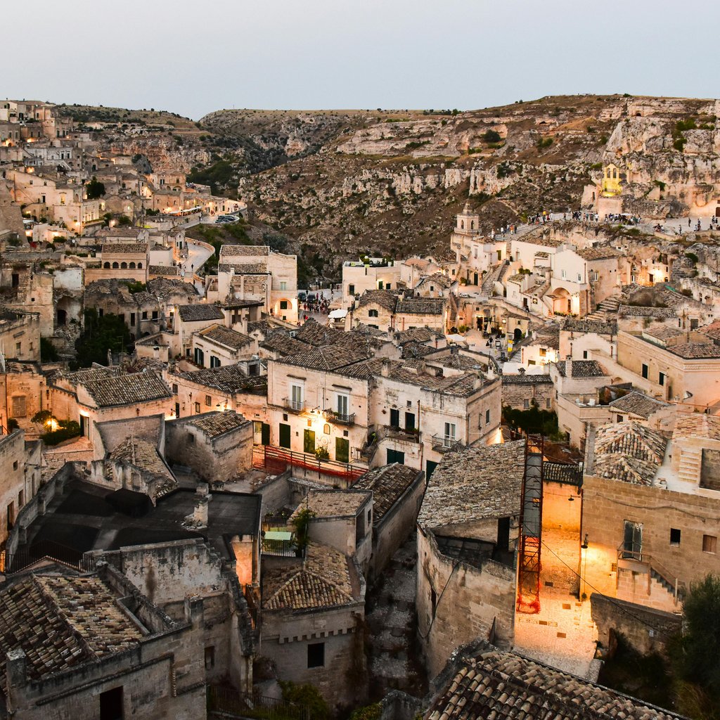 Breathtaking view of Matera's ancient stone cityscape under twilight, Italy.