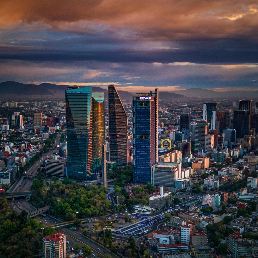 Stunning aerial view of Mexico City's skyline with skyscrapers and vibrant sunset colors.