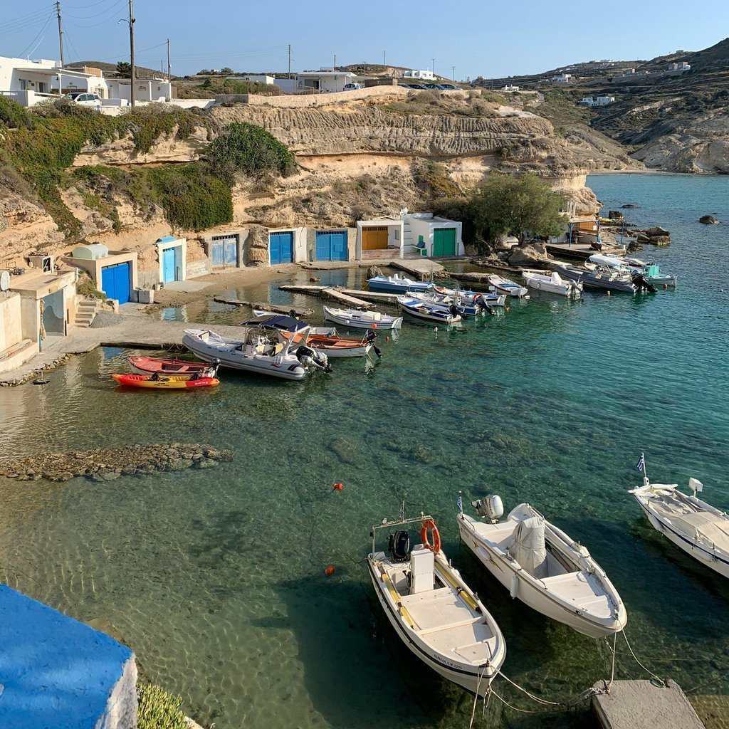 Beautiful Mandrakia harbor in Greece, showcasing colorful boats and traditional architecture.